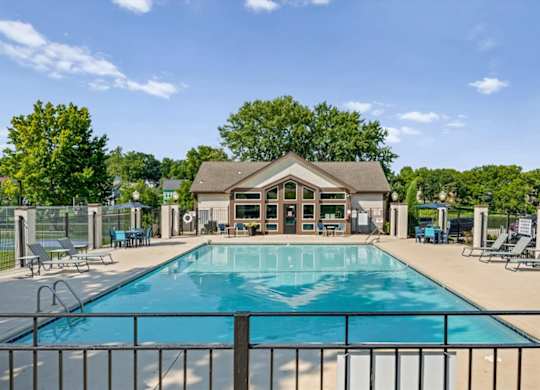 Resort-style swimming pool with lounge chairs and the community clubhouse in the background.