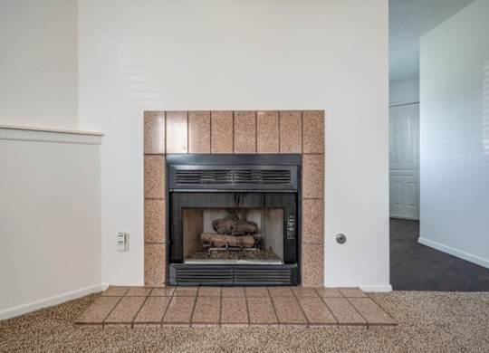 Tile-surround fireplace in a Millcreek Woods apartment home living area.