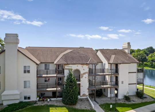 Exterior apartment building with private balconies and landscaped grounds.