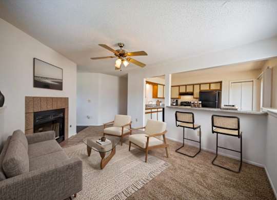 Open-concept living room featuring a fireplace, breakfast bar seating, and adjacent kitchen.