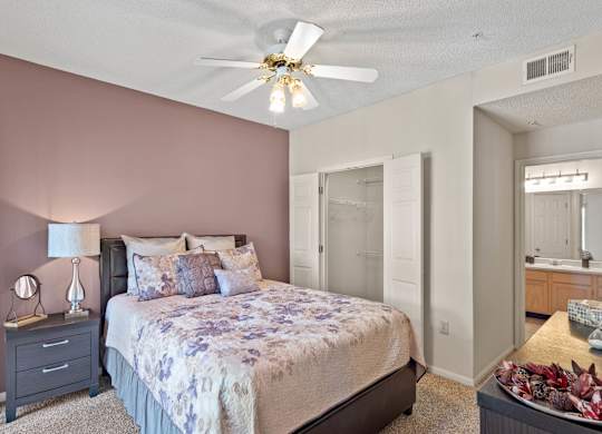 A bedroom with a ceiling fan, walk-in closet and master bathroom.