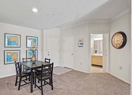 A dining room with an entryway to the bathroom.