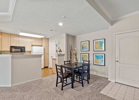 A carpeted dining room with front door access.
