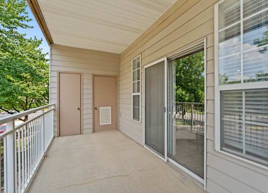 A private patio with a storage closet, window and sliding glass door.
