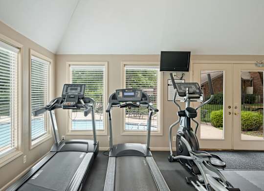 A home gym with treadmills and elliptical machines.