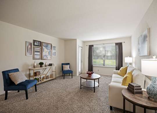 A living room with a blue chair and a white couch.