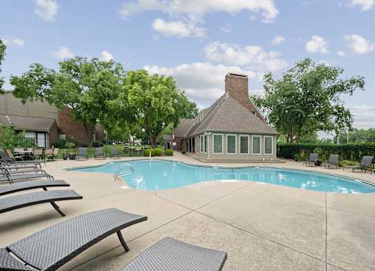 A pool with a small building behind it.
