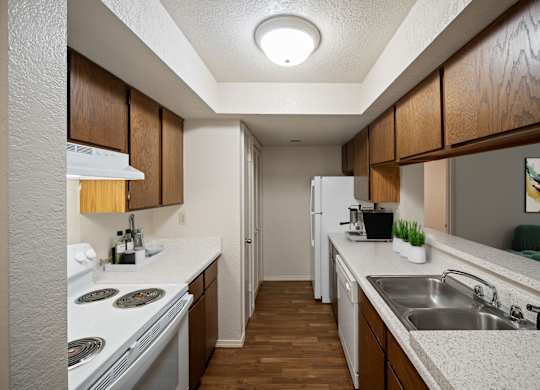 A kitchen with white appliances and wooden cabinets.