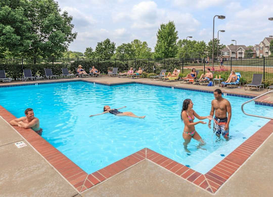 A group of people are enjoying a sunny day at the pool.