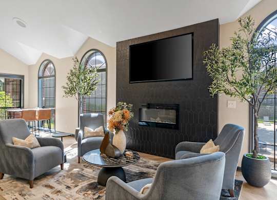 A living room with grey chairs and a black television.