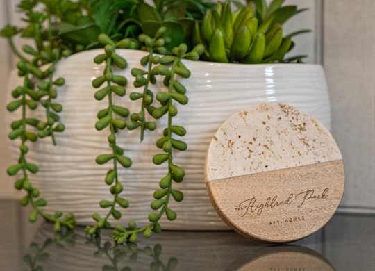 A white ceramic pot with a plant and a wooden box with the text