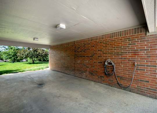 Covered car wash bay with hose hookup at Stonebriar Apartments in Overland Park, KS