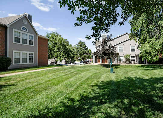 Open grassy courtyard between apartment buildings at Stonebriar Apartments Overland Park, KS