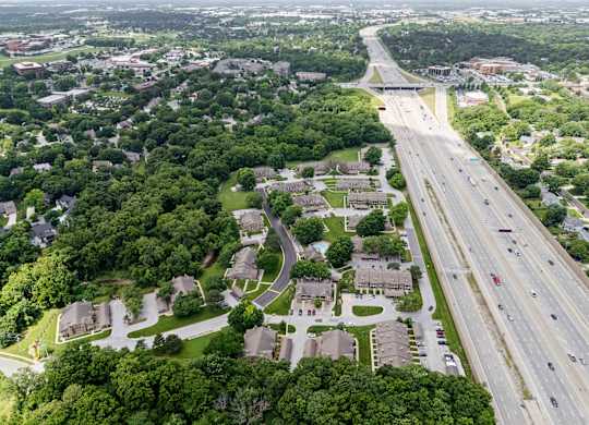 A highway runs through a residential area with houses on both sides.
