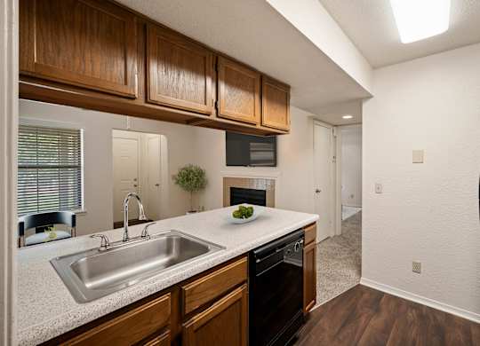 A kitchen with wooden cabinets and a black refrigerator.