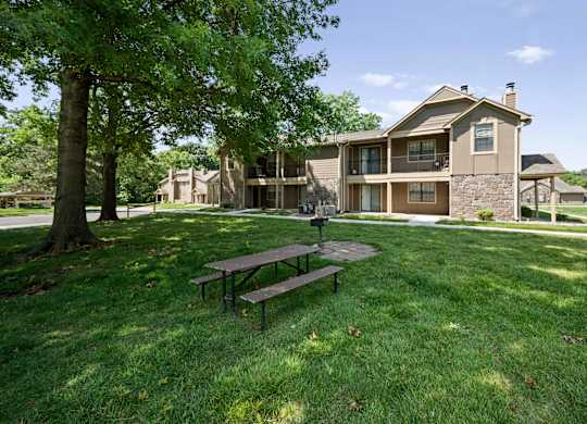 A house with a brown roof and a green lawn.