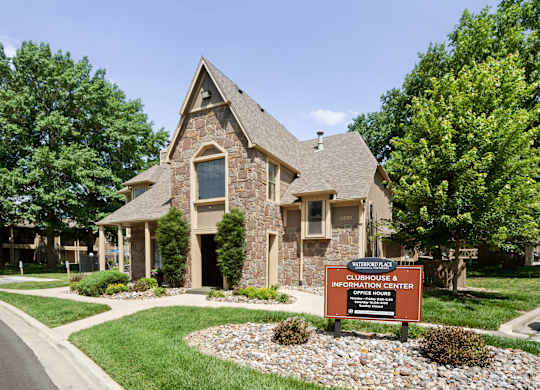 A stone house with a sign in front that says