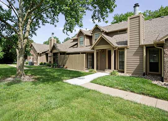 A row of houses with a tree in front of the first one.