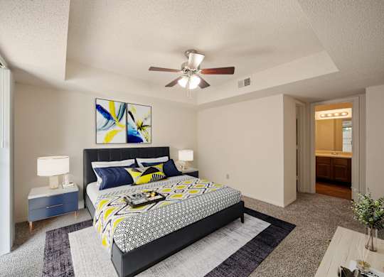 A bedroom with a large bed and a ceiling fan.