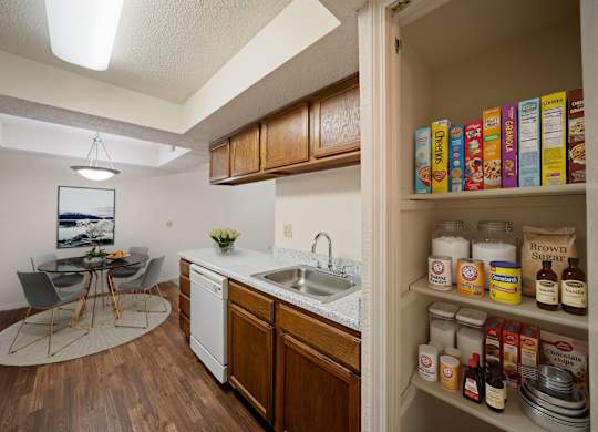A kitchen with a white fridge and a white sink.