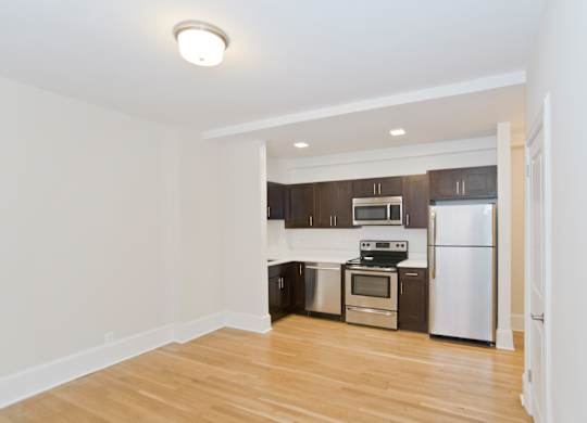 A kitchen with a white fridge and stove top oven.