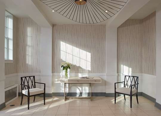 a lobby with a table and chairs and a large chandelier