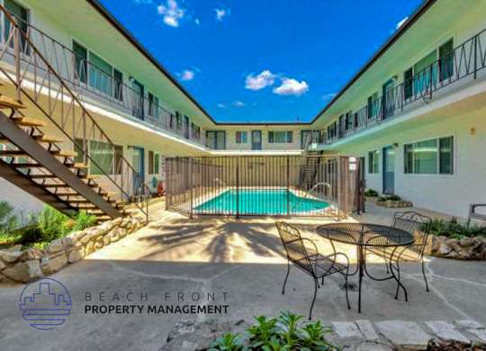 A pool area with a staircase leading to a balcony.