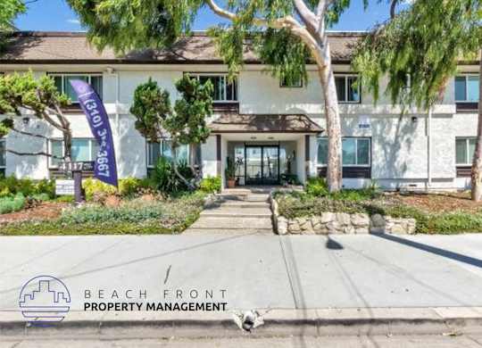 a beach front property management building with a dog in front of it