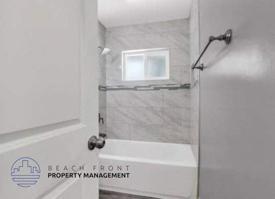a white bathroom with a tub and a window in it