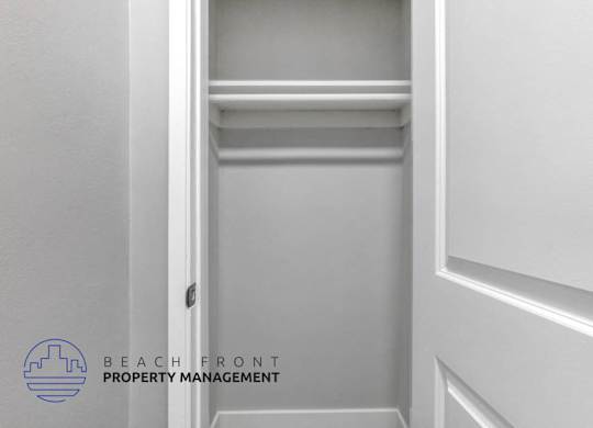 a white closet with a white wall and a white door