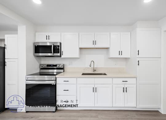 A kitchen with white cabinets and appliances.