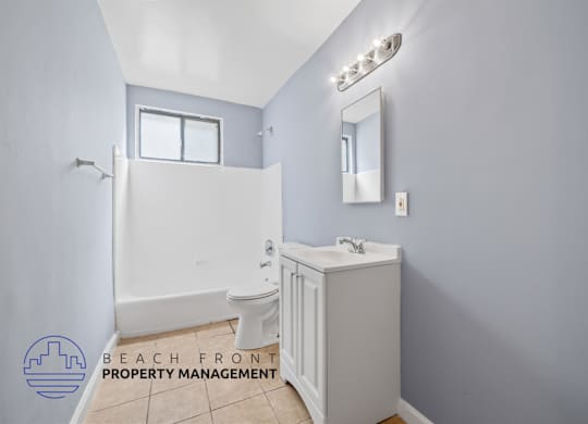 A bathroom with a toilet, sink, and mirror.