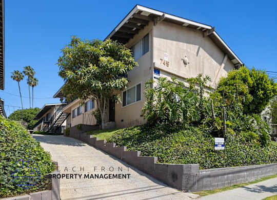a home with stairs and a sidewalk in front of it