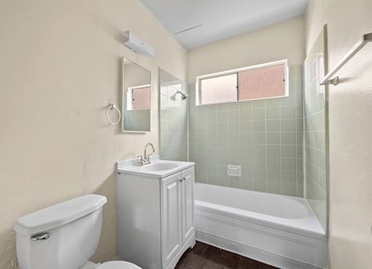 A white toilet sits next to a white sink in a bathroom.