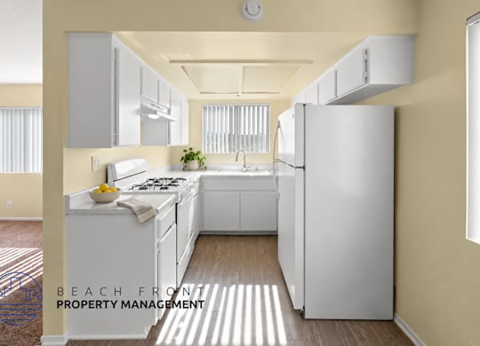 A kitchen with a refrigerator, sink, and stove.