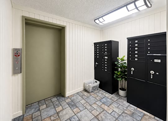 A room with a door and a wall of lockers.