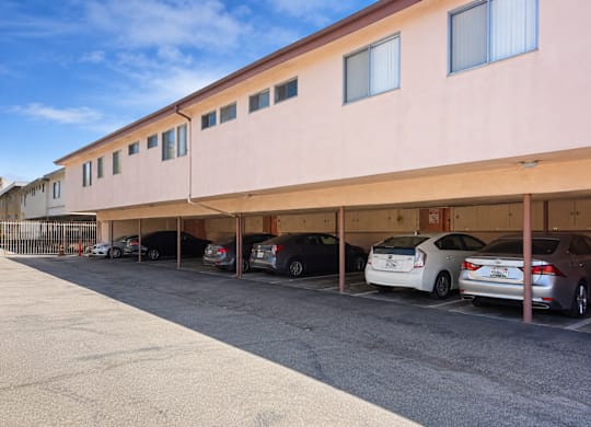 A parking lot with cars parked in front of a building.