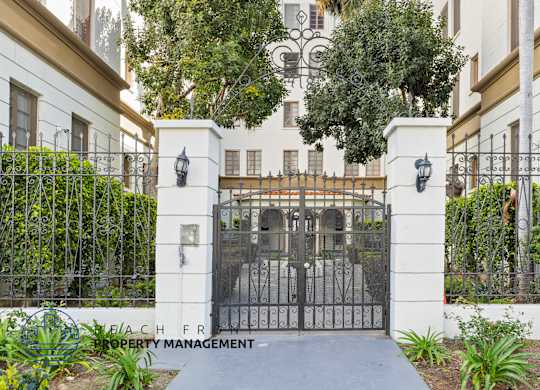 A gated entrance to a property with a sign that says Beachfront Property Management.