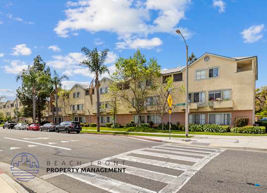 A street view of a residential area with a crosswalk and apartment buildings.