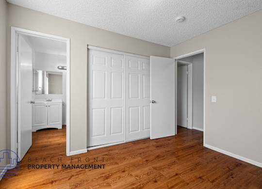 A room with a white door and a mirror on the wall.