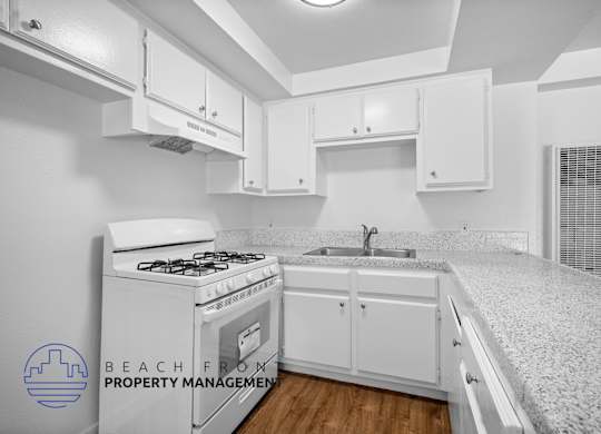 an image of a kitchen with white cabinets and a white stove and white counter tops