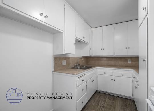 a kitchen with white cabinets and white appliances and a sink