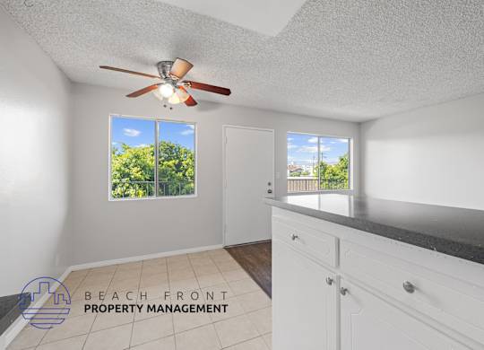 a kitchen with a counter top and a ceiling fan