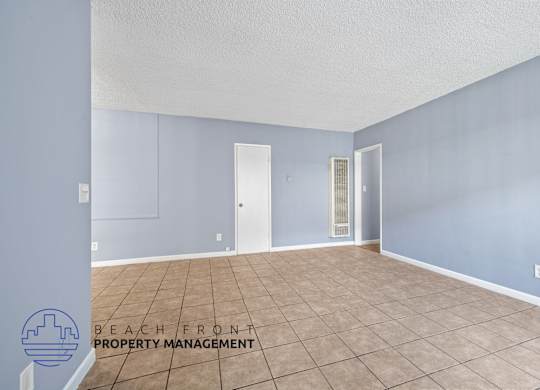 A room with tile flooring and a logo for Beach Front Property Management.