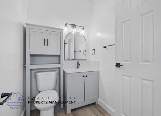 A bathroom with a toilet, sink, and medicine cabinet.
