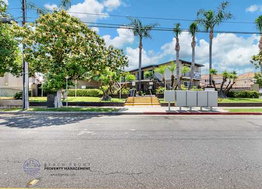 A street view with a sign for Beach Front Property Management.