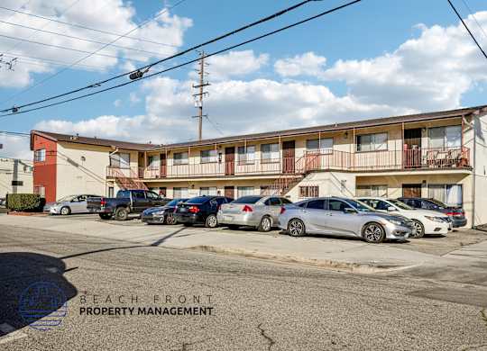 A parking lot with cars and a building with the words
