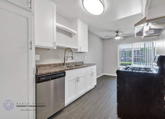 A kitchen with white cabinets and a stainless steel dishwasher.