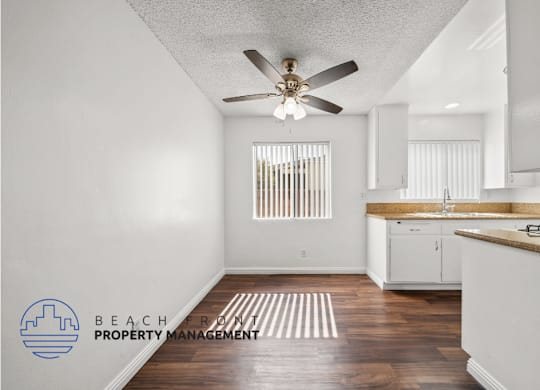 a kitchen with white cabinets and a ceiling fan