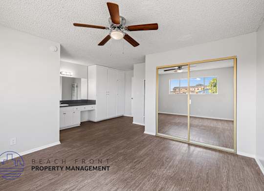 a living room with a ceiling fan and a mirror